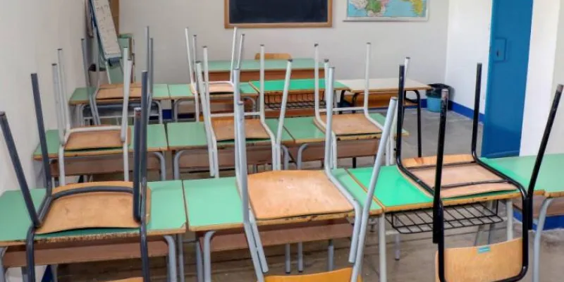Aula de colegio cerrada con todas las sillas sobre las mesas