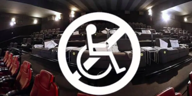 Imagen de una sala de cine y el logo de persona en silla de ruedas tachado