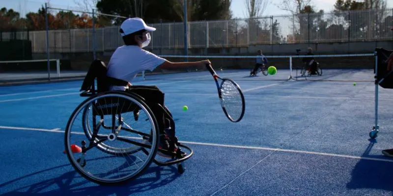Niño jugando al tenis en silla durante el evento Villaverde Sport4All