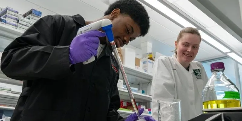 Leon Johnson, estudiante de primer año de neurociencia, y Alice McQueney, estudiante de posgrado de segundo año, pipetean dicromato de potasio para un experimento