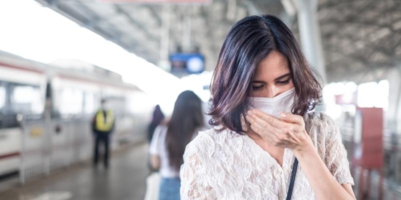 Mujer asiática con máscara para evitar el anochecer a las 2.5 p.m., mala contaminación del aire y coronavirus