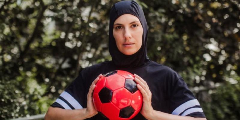 Mujer con hiyab sosteniendo una pelota