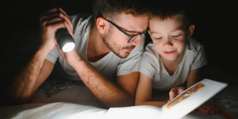 Niño leyendo un cuento con su padre