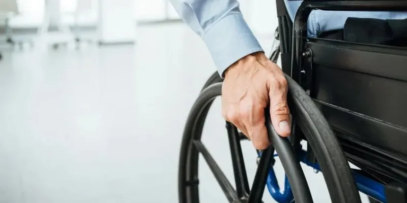 Mano de una persona en silla de ruedas