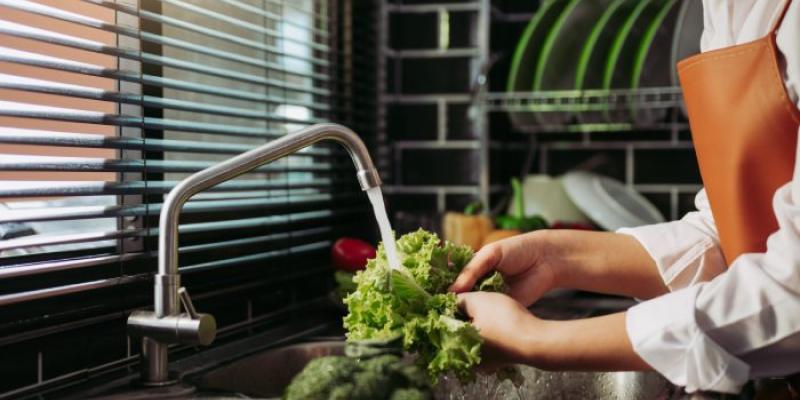 Mujer lavando una lechuga