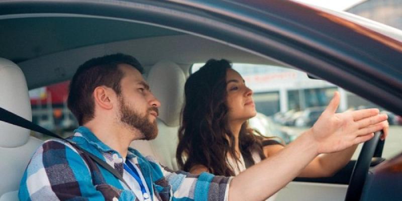 Una alumna de autoescuela con el profesor en el coche 