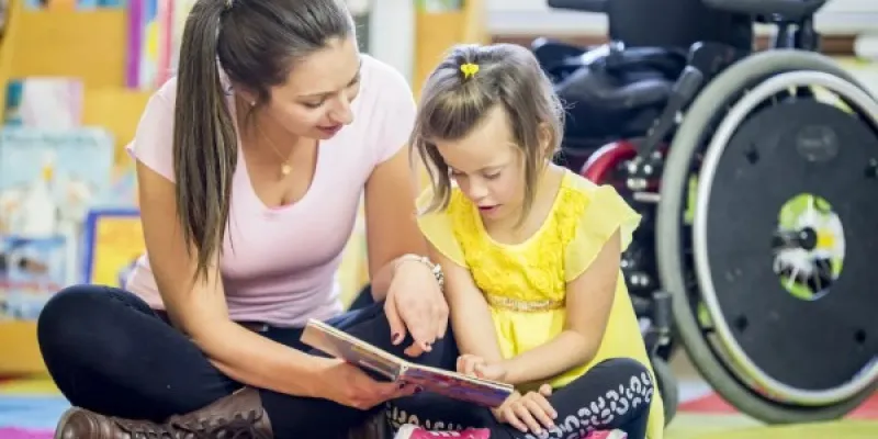 Una niña con discapacidad junto a su profesora.