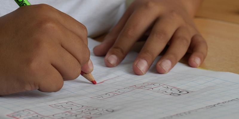 Manos de un estudiante en clase