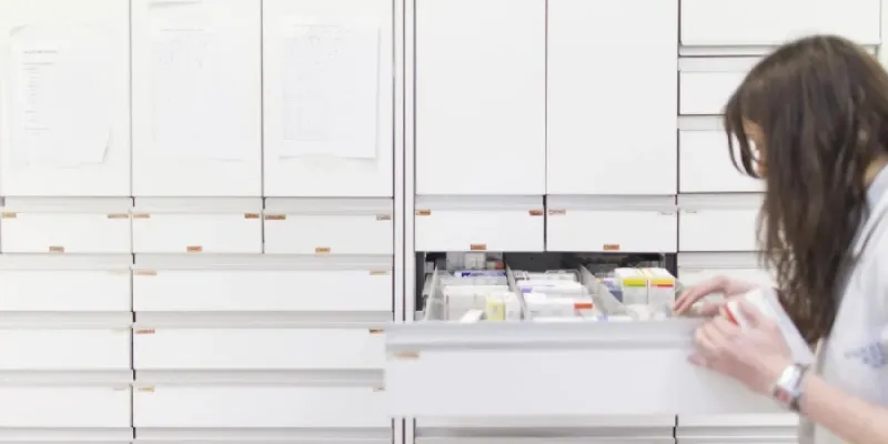 Una trabajadora busca fármacos en una farmacia. 