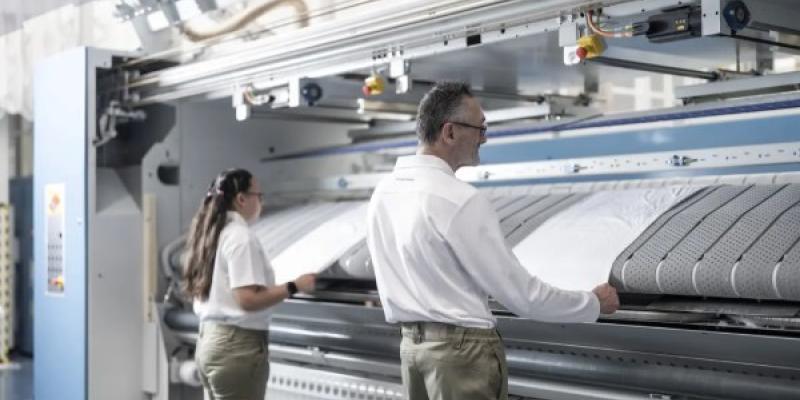 Dos personas con discapacidad e su puesto de trabajo en Ilunion TextilCare.