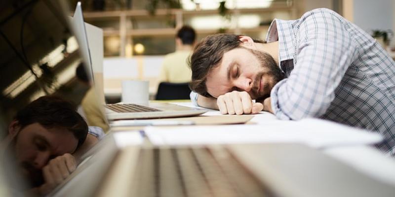 Trabajador agotado descansando en su mesa