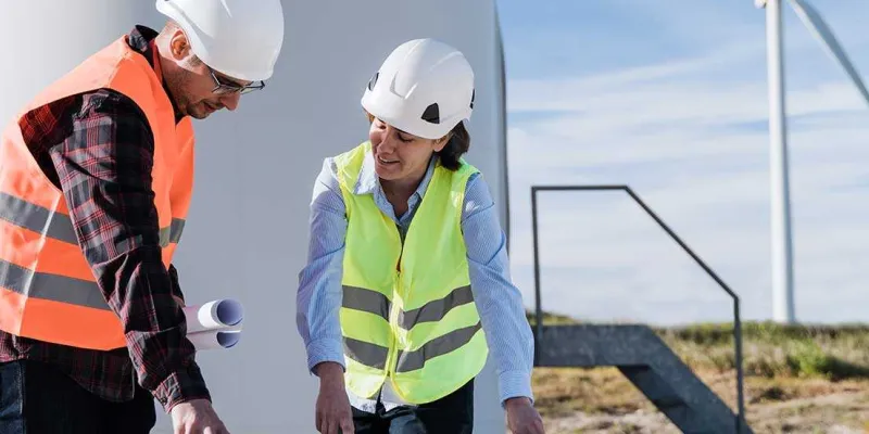 Dos personas trabajando en el sector de la energía eólica
