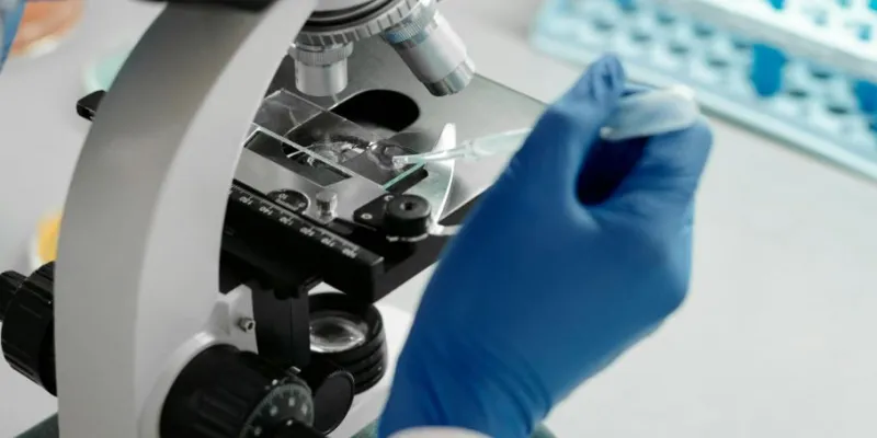 Manos de una mujer científica con un microscopio