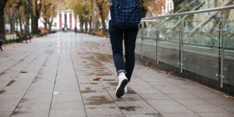 Una estudiante camina por una calle 