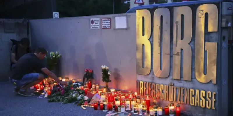 Dos jóvenes dejan velas en la puerta del instituto de Graz.