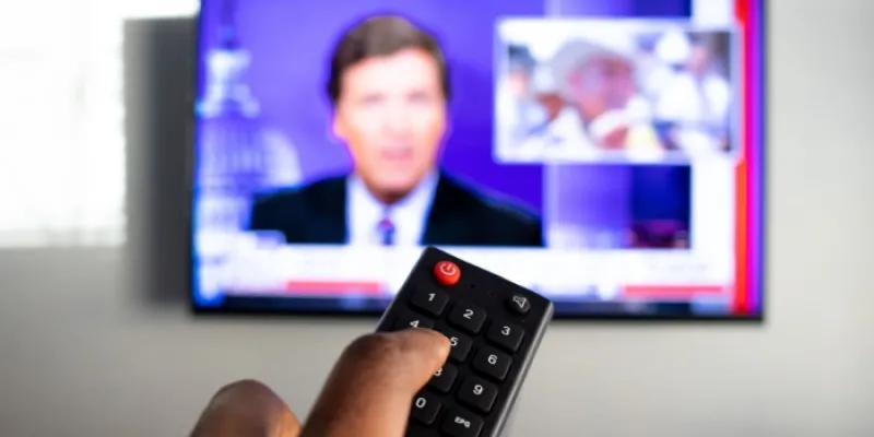 Persona pulsando el mando de la televisión
