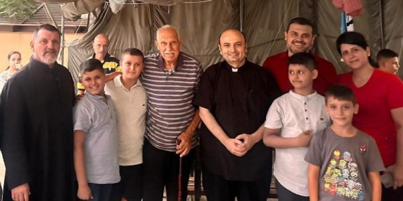 El párroco posa junto a algunos refugiados en el exterior de la iglesia de la Sagrada Familia en Gaza | Foto cedida por el padre Romanelli