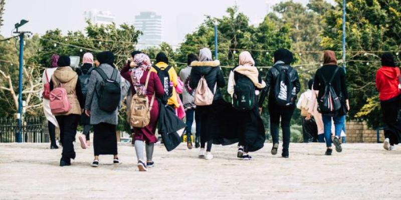 Varias personas caminando de espaldas 