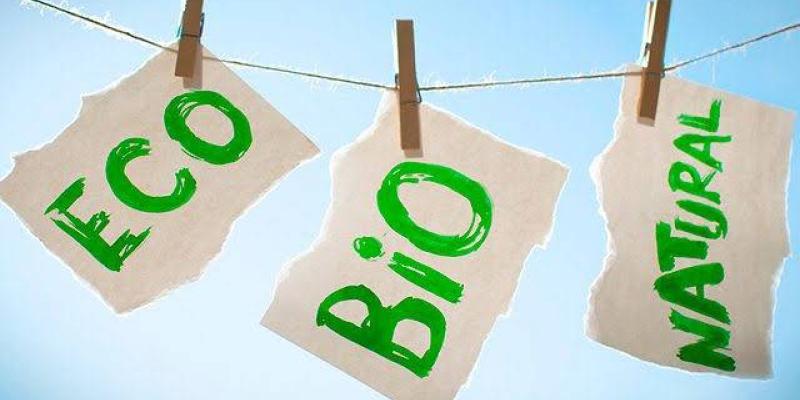 Infografía que muestra etiquetas de Eco, Bio y Natural, tendidas en una cuerda de tender ropa