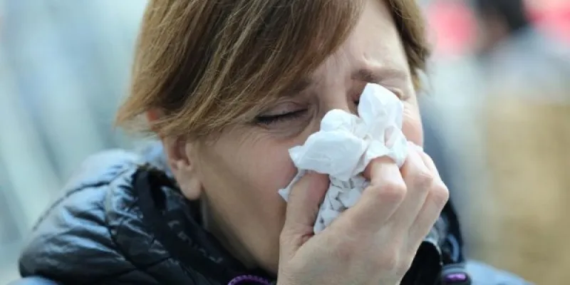 Señora sonándose los mocos por la gripe