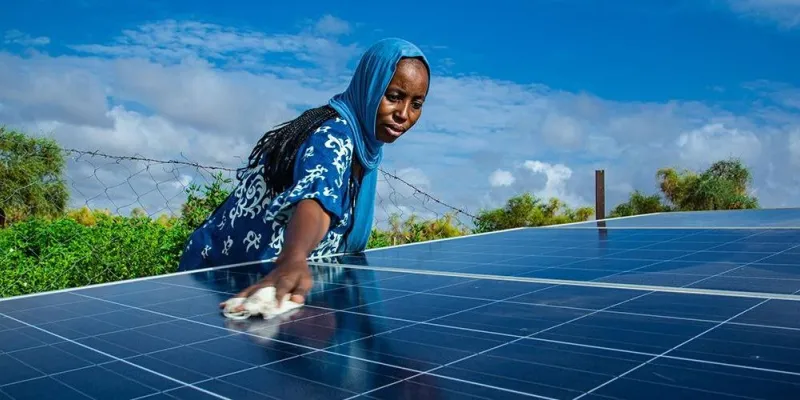 Una mujer limpia un panel solar 