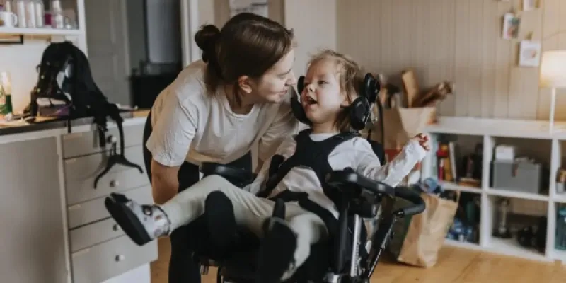Una madre junto a su hija con grave discapacidad motora.