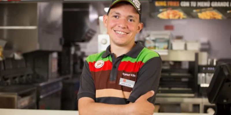 Joven con discapacidad intelectual trabajando en un restaurante Burger King, ejemplo de inclusión laboral