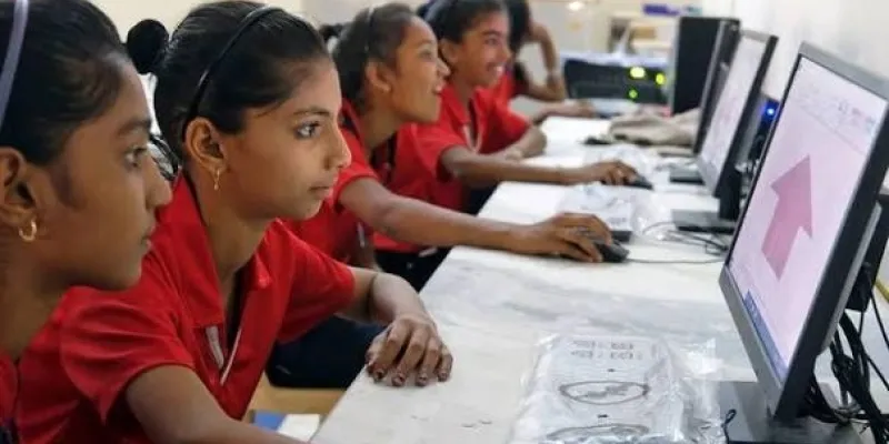 Niñas aprendiendo a usar herramientas digitales en una escuela en India.