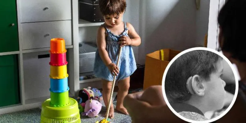 Una niña jugando. A la derecha, un niño pequeño con un audífono. / EL NORTE