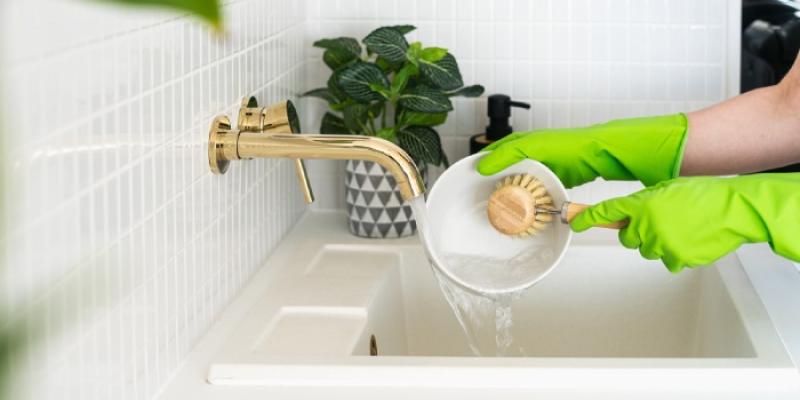 Retrato de las manos de una persona que utiliza guantes para limpiar 