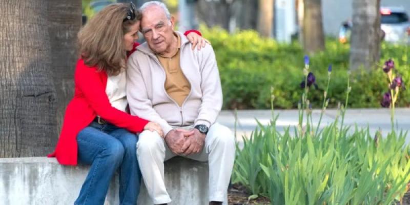 Una mujer abraza a un hombre mayor con síntomas de demencia