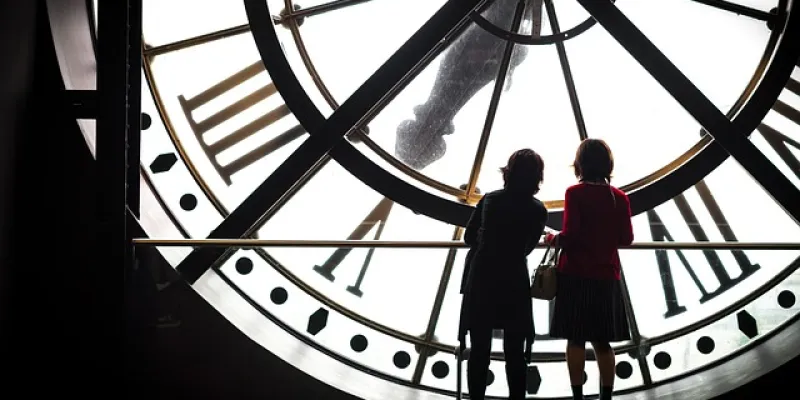 Dos mujeres de espaldas frente a un reloj