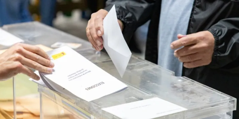 Un hombre introduce su voto en una urna 