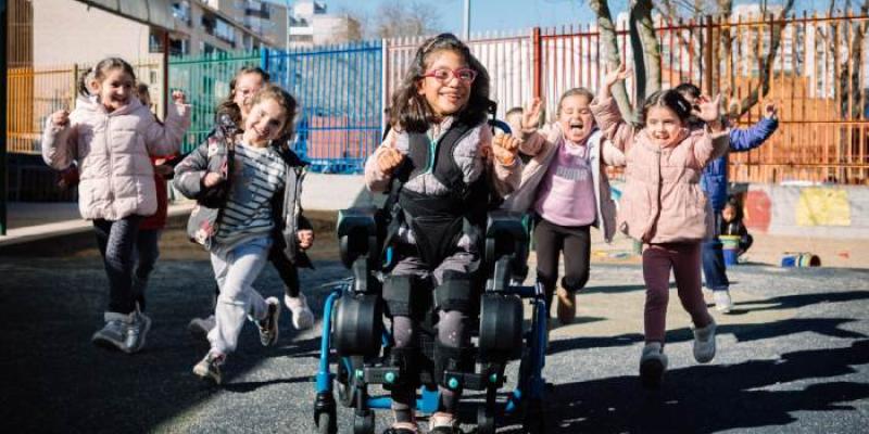 Miverva, con el exoesqueleto rodeada de compañeros del colegio