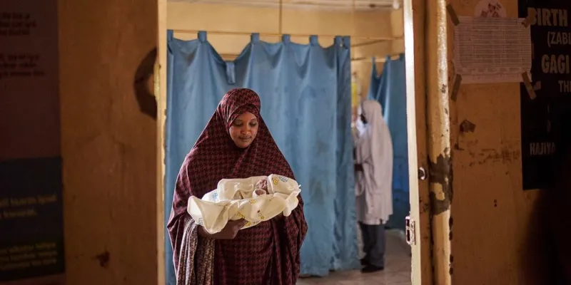 Una mujer sostiene a un bebé recién nacido dentro de la sala de parto de un hospital en el estado de Sokoto, Nigeria.