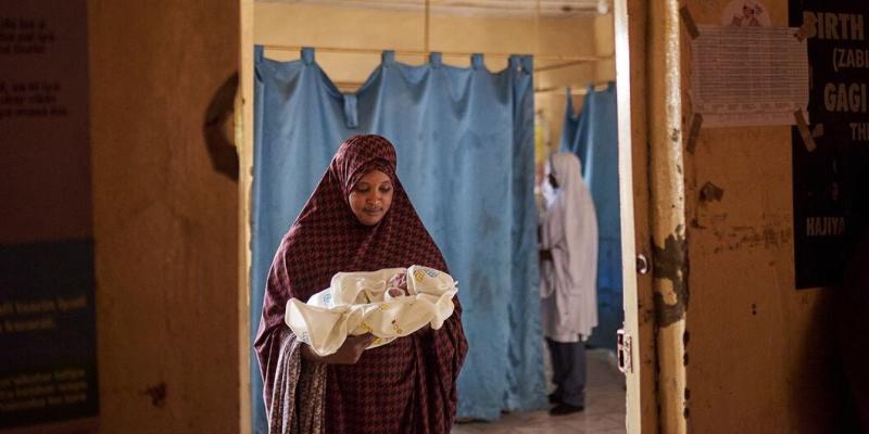 Una mujer sostiene a un bebé recién nacido dentro de la sala de parto de un hospital en el estado de Sokoto, Nigeria.