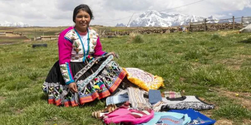 La presidenta de Atiptalla con las prendas elaboradas con lana de alpaca