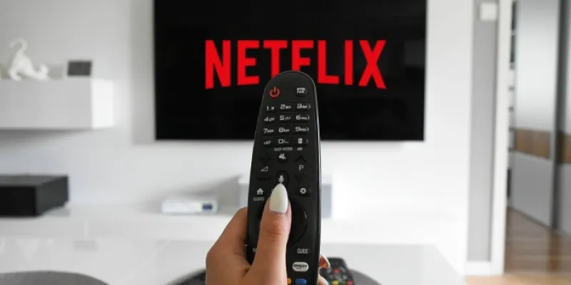 Persona con un mando apuntado a su tele viendo Netflix