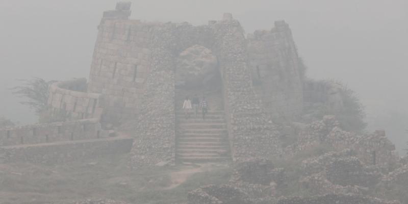 Visitantes en el fuerte de Tughlakabad en medio de una densa niebla tóxica en Nueva Delhi