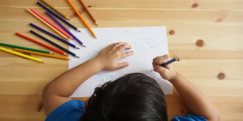 Un niño dibuja en su pupitre 