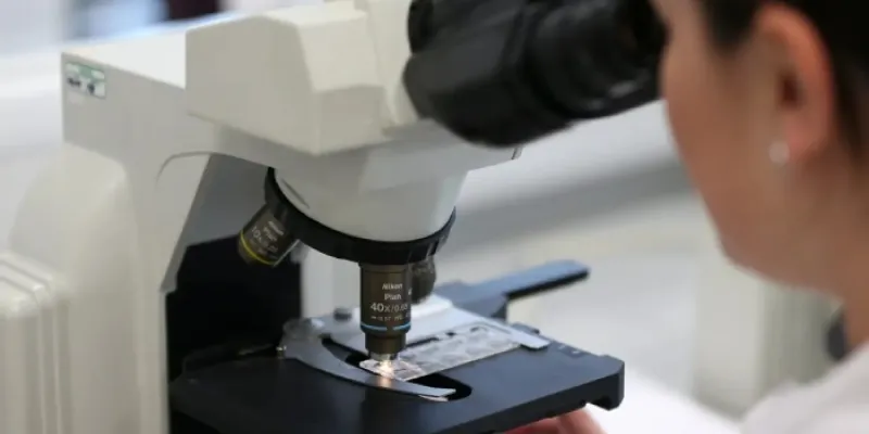 Mujer mirando por el microscopio