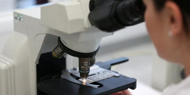 Mujer mirando por el microscopio