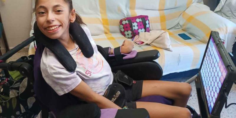 Laura Caño sonríe junto a su lector de ojos | Foto cedida por la familia para Servimedia Laura Caño sonríe junto a su lector de ojos | Foto cedida por la familia