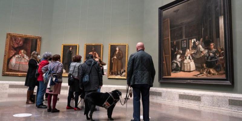 Una persona con discapacidad con su perro de asistencia en el Museo del Prado 