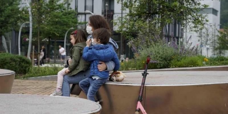 Una mujer sentada junto a una niña y un niño 