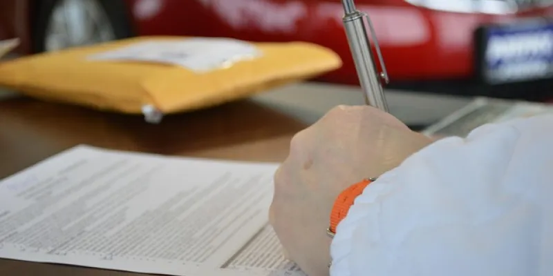 Mano de una persona firmando un préstamo