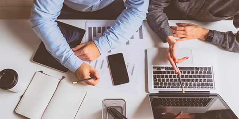 Dos personas trabajando en una pyme con sus ordenadores