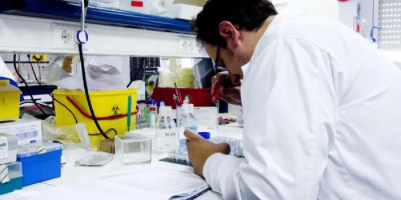 Un científico mira a través de un microscopio 