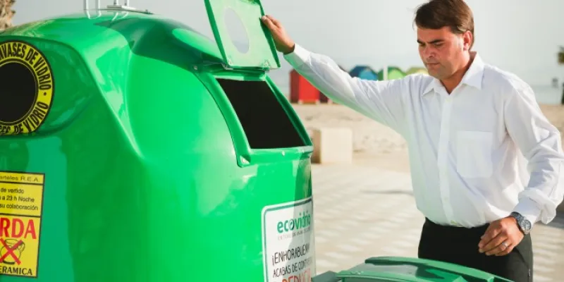Un hombre se dispone a reciclar vidrio cerca de una playa 