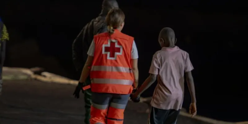 Un trabajador de la Cruz Roja atiende a menores migrantes llegados a Canarias